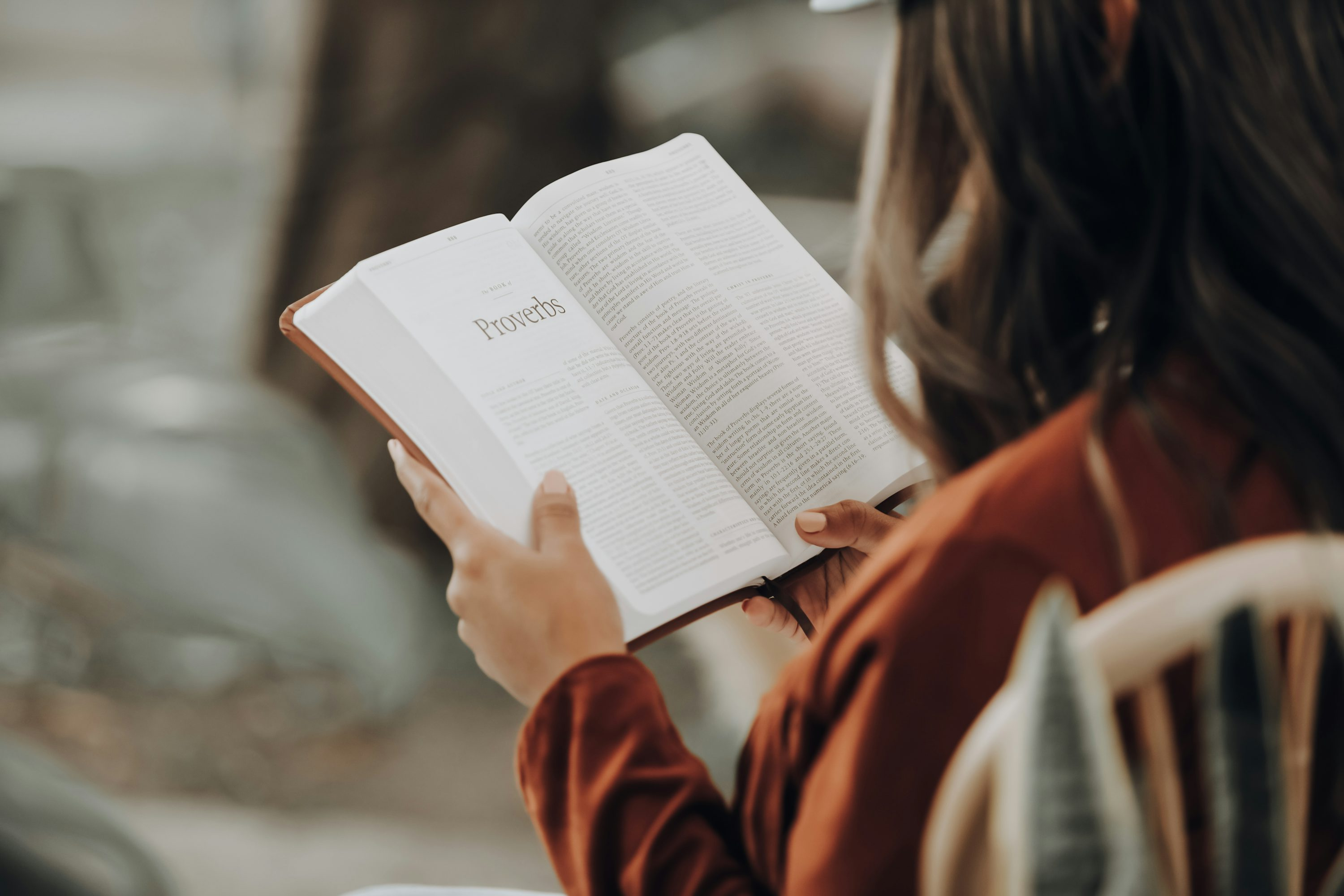 A person reading a book outdoors