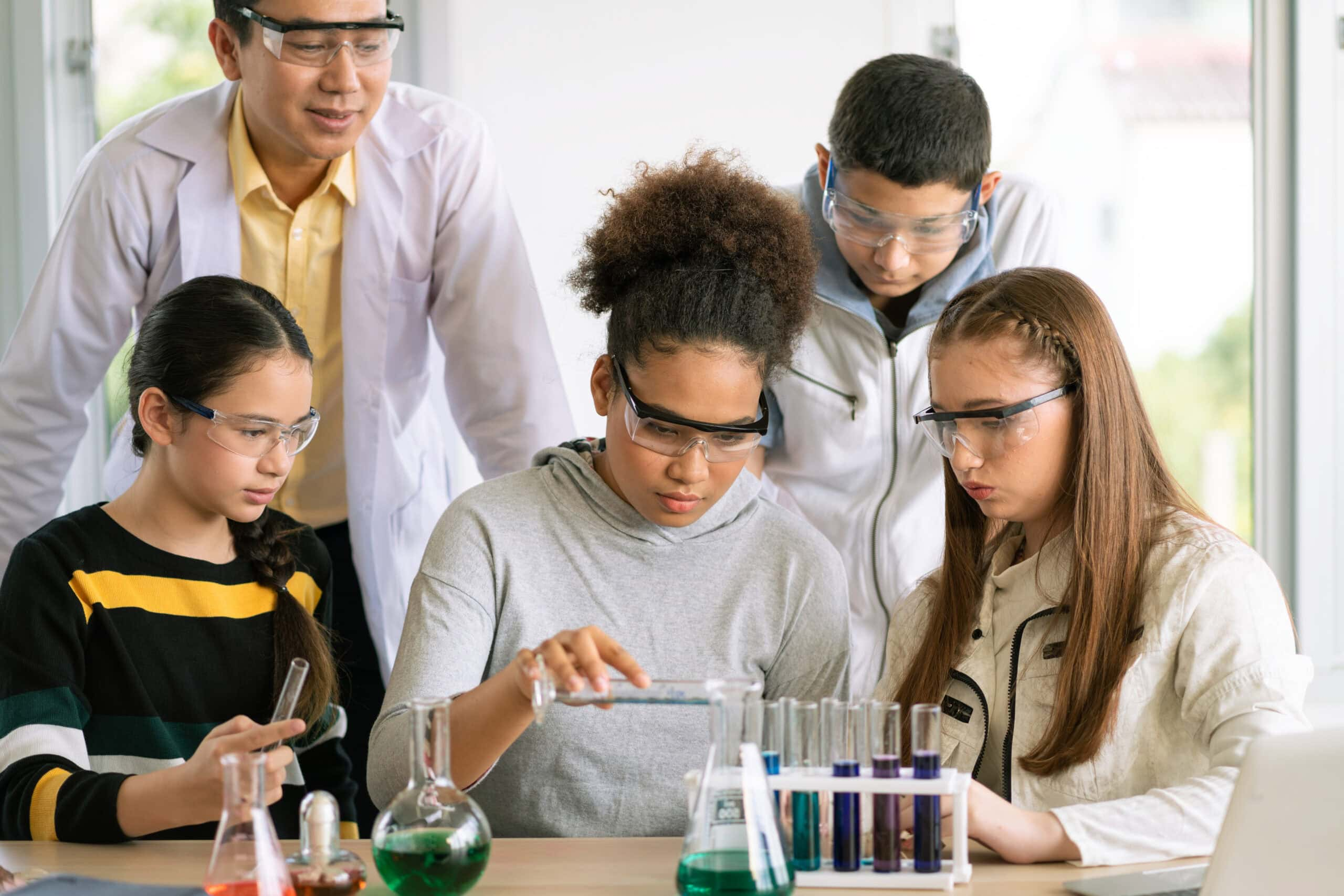 Students and a teacher conducting a science experiment in a lab