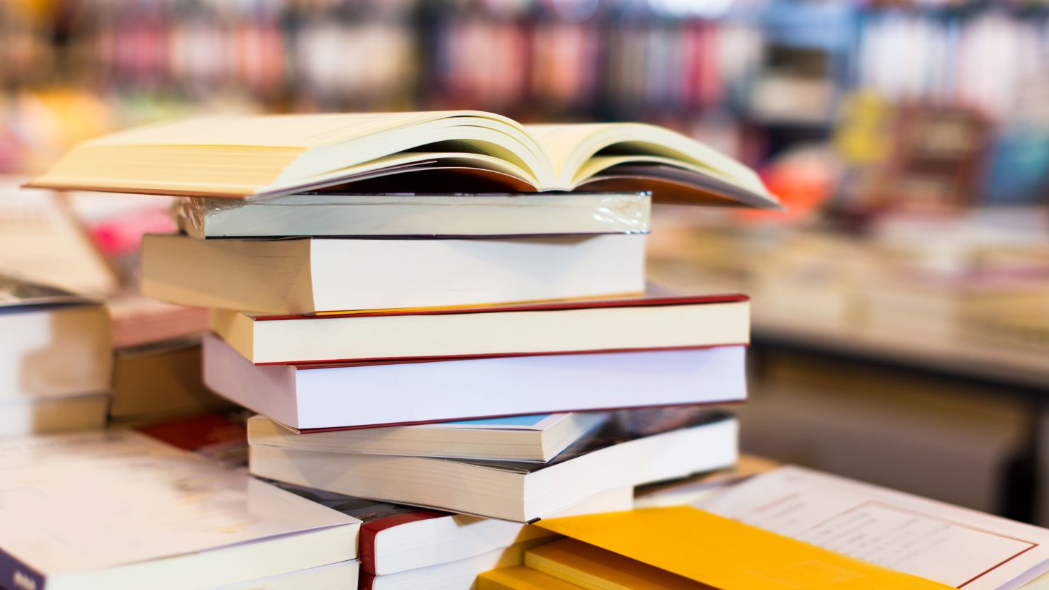 A stack of books on a table in a library